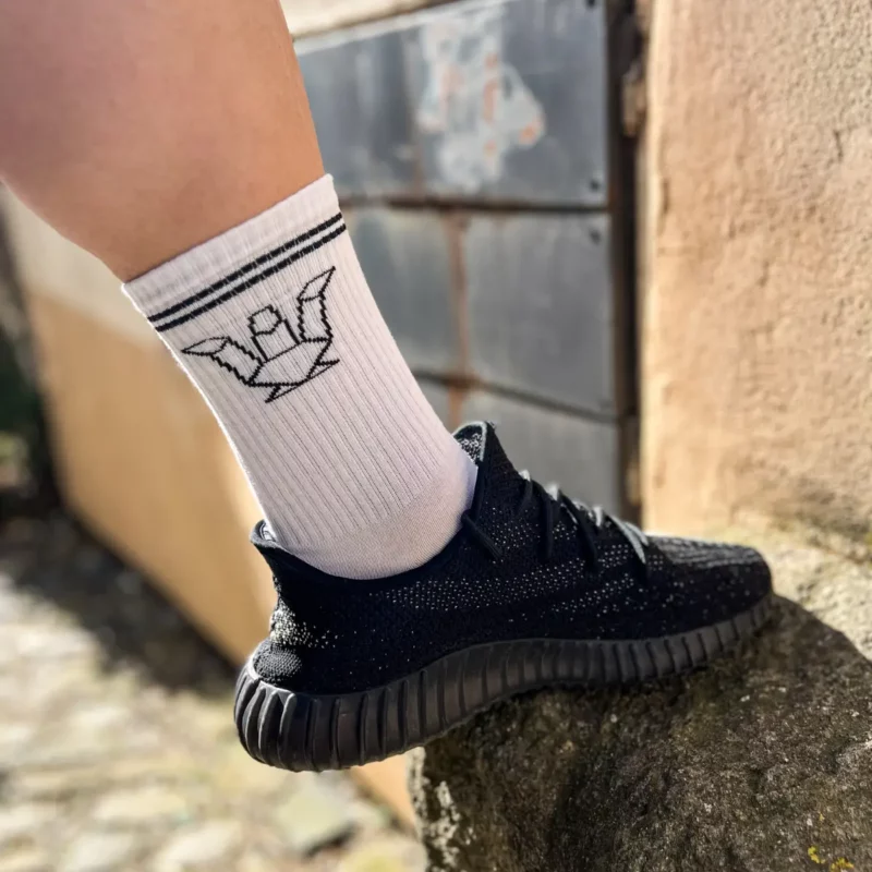 Streetwear kombinace bílé vysoké ponožky TOMÁŠ DRAGON a černých tenisek v městském prostředí